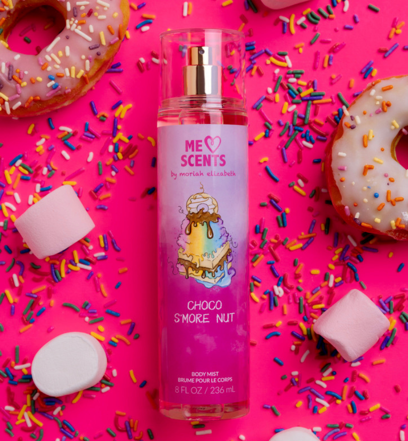 The Choco S'more Nut Body Mist displayed with sweets like sprinkles, marshmallows, and donuts.