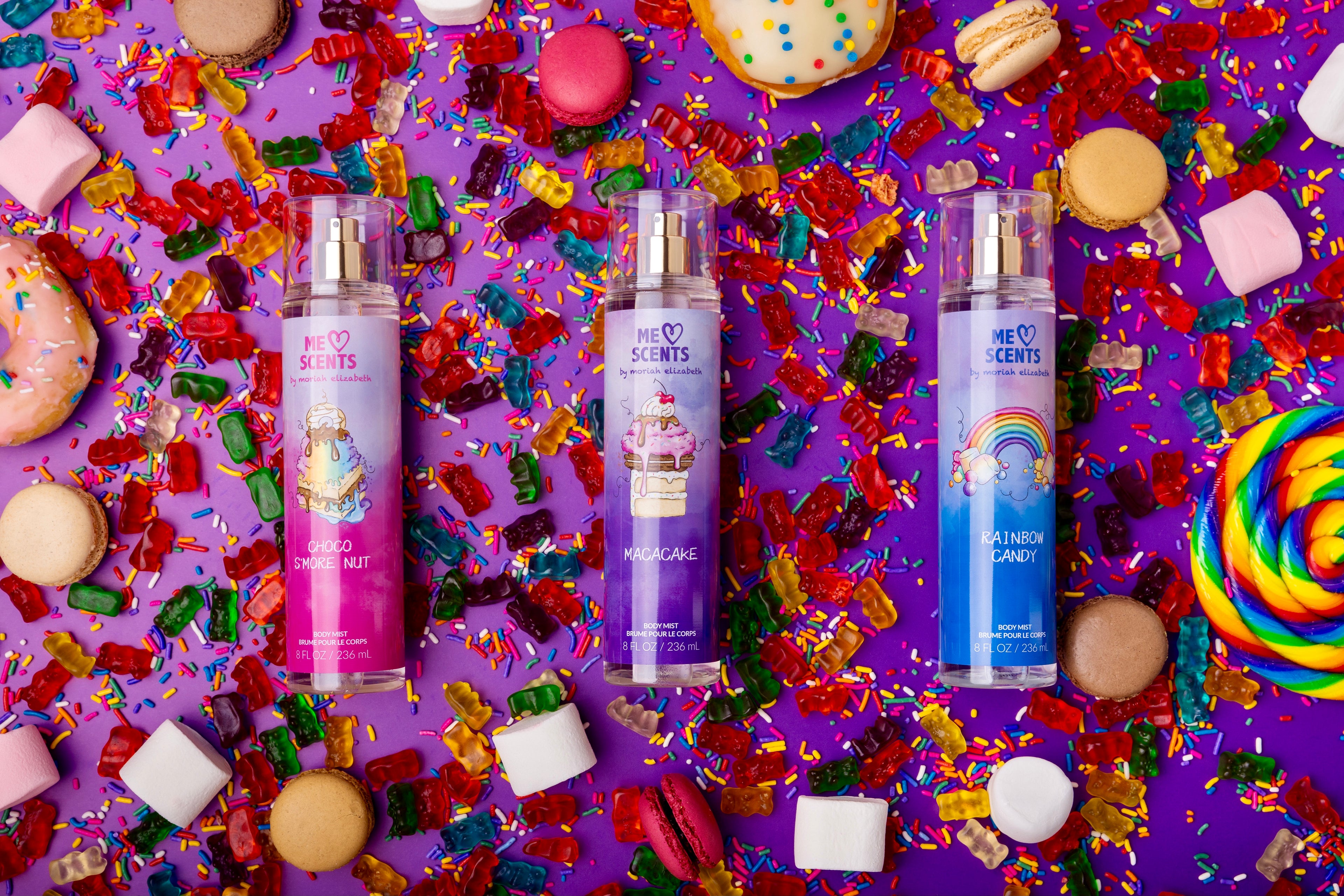 Discover the vibrant trio of ME Scents body mists by Moriah Elizabeth Beauty, showcased against a playful candy-inspired backdrop. Sweet, fun, and irresistible!