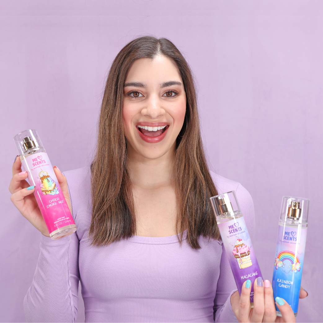 Moriah Elizabeth is happily displaying all three body mists—Rainbow Candy, Choco S'more Nut, and Macacake—from her ME Scents collection.