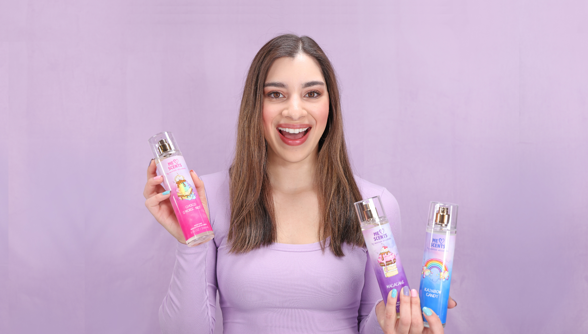 Moriah Elizabeth beams with joy as she proudly showcases her three mists from the ME Scents collection.