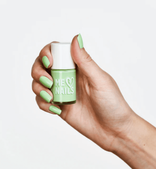 A hand holds the Key Lime Cream nail polish while showcasing nails painted in the same shade.