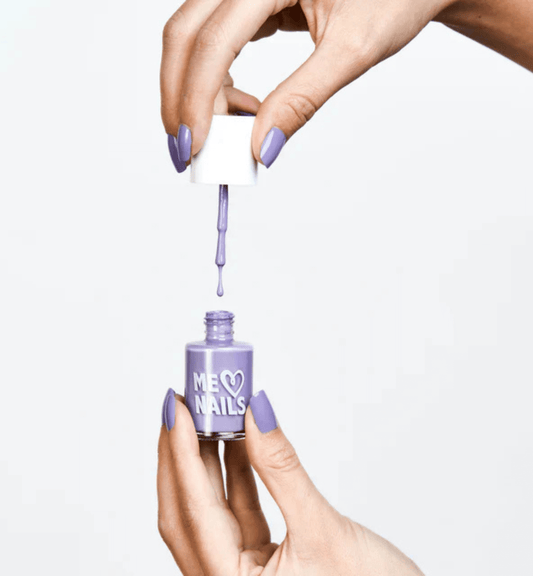 A hand holds the Pale Plum nail polish while showcasing nails painted in the same shade.