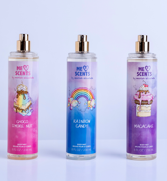 The three body mists—Rainbow Candy, Choco S'more Nut, and Macacake—from the ME Scents Collection displayed side by side.







